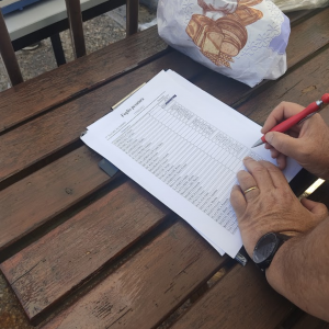 Foto in cui si vede una mano che scrive dei numeri all'interne della tabella presente nel foglio pesatura della 1° gara sociale